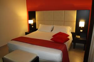 a bedroom with a bed with two red pillows at Rama Palace Hotel in Casalnuovo di Napoli +87 photos