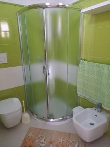 een badkamer met een douche, een toilet en een wastafel bij Casa Giada in Porto Cesareo