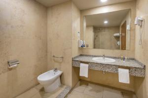 a bathroom with a toilet and a sink and a mirror at Las Palmeras Affiliated by FERGUS in Fuengirola