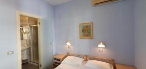 a bedroom with a bed with two white pillows at Hotel Sud Est by Fam Rossetti in Lavagna