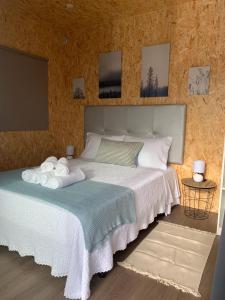 ein Schlafzimmer mit einem Bett mit Handtüchern darauf in der Unterkunft MyStay - Bungalow in Quinta dos Sobrais in Valença