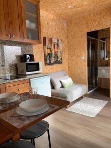 ein Wohnzimmer mit einem Sofa und einem Tisch in der Unterkunft MyStay - Bungalow in Quinta dos Sobrais in Valença