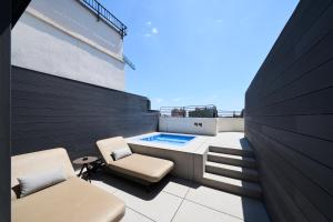 a rooftop patio with a hot tub and two chairs at Catalonia Passeig de Gràcia 4* Sup in Barcelona