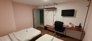 Misto Hotel في كوتا كينابالو: غرفة فندقية بسرير ومكتب مع تلفزيون