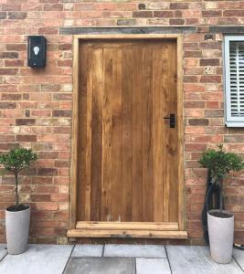 una puerta de madera en el lateral de un edificio de ladrillo en Lodge Barn Annexe 