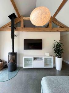 a living room with a fireplace and a flat screen tv at Lodge Barn Annexe 