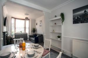 a dining room with a table and a living room at Clyde Villa in Kent