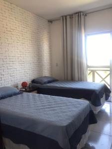 Een bed of bedden in een kamer bij Apartamento com vista para o mar, piscina , deck , playground e estacionamento .