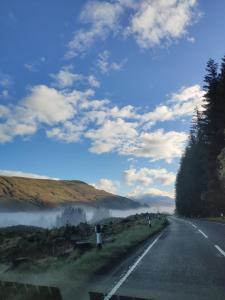 een weg met mist aan de kant van de weg bij CRAIGLEA HEATHER in Killin