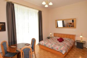 a bedroom with a bed and a table and a mirror at Apartments Vektor Vila Golf in Rogaška Slatina