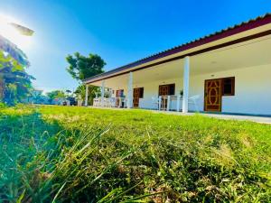 a house with a green lawn in front of it at Ratnam Hotel Jaffna in Jaffna