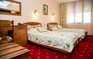 a hotel room with two beds and a dresser at Boutique Hotel VSK Kentavar in Dryanovo