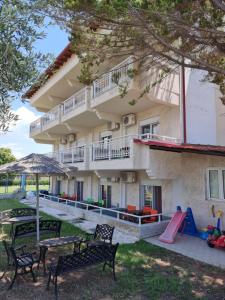 ein Gebäude mit Spielplatz, Tischen und Stühlen in der Unterkunft Hotel Nautilos in Sozopoli