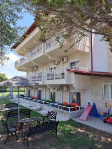 un edificio con parque infantil, mesas y sillas en Hotel Nautilos, en Sozopoli