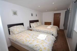 1 dormitorio con 2 camas con sábanas amarillas en No 28C St Benedict en Glastonbury