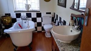 a bathroom with a tub and a sink and a toilet at 29onTait Guest House in Pretoria