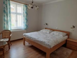 a bedroom with a bed and a chair and a window at Apartmány U Mariánské kaple in Česká Kamenice