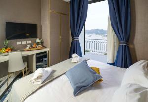 um quarto com uma cama com cortinas azuis e uma janela em Hotel Cala Moresca em Bacoli