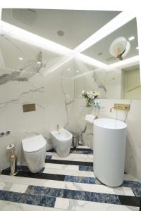 a white bathroom with a toilet and a bidet at Hotel Cala Moresca in Bacoli