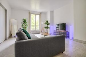 a living room with a couch and a table at 2 Bedrooms Tour Eiffel Rapp in Paris