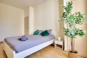 a bedroom with a bed with purple and green pillows at 2 Bedrooms Tour Eiffel Rapp in Paris