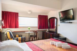 1 dormitorio con 1 cama, TV y mesa en Villa Nico, en Zadar