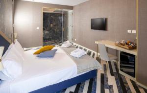 a bedroom with a bed and a desk and a television at Hotel Cala Moresca in Bacoli