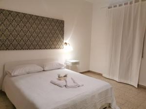 een slaapkamer met een wit bed en een hoofdeinde bij Al Cortile in Reggio di Calabria
