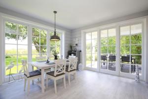 a dining room with a table and chairs and windows at Redewisch Lee und Luv Ferienwohnung Lee in Redewisch