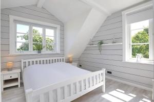 a white bedroom with a crib and two windows at Redewisch Lee und Luv Ferienwohnung Lee in Redewisch