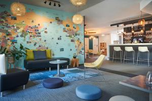 a living room with a map of the world on the wall at Kyriad Lille Gare - Grand Palais in Lille