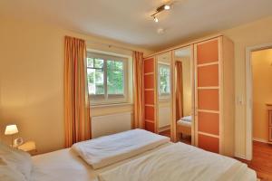 een slaapkamer met een wit bed en een raam bij Villa am Meer Villa am Meer Strandallee 48 Appartement 07 in Timmendorfer Strand