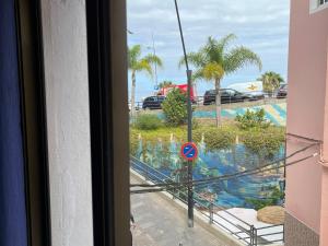 uitzicht op een zwembad vanuit een raam bij CORNELIAS HOME 5A playa in Los Cristianos