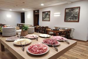 a table with plates of food on top of it at Hotel Saurat in Espot
