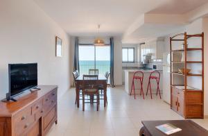 a kitchen and living room with a table and chairs at Sea You Apartamentos Valencia Port Saplaya in Port Saplaya