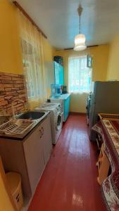 a kitchen with a sink and a stove top oven at Guest house VL in Akʼori