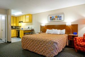 a hotel room with a bed and a kitchen at Days Inn by Wyndham Mission Valley-SDSU in San Diego