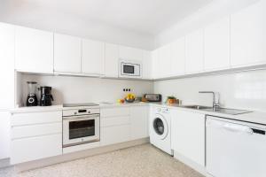 una cucina bianca con armadi bianchi e lavastoviglie di Punto Fijo - 3 minutes walking to Beach San Telmo a Puerto de la Cruz