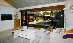 ein Wohnzimmer mit einem weißen Sofa und einem Tisch in der Unterkunft Elegant Villa Bali style in Blue Bay in Blue Bay