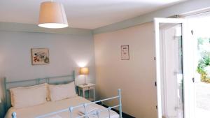 ein Schlafzimmer mit einem Bett, einer Lampe und einem Fenster in der Unterkunft Gîte Chez Julie in Sarlat-la-Canéda