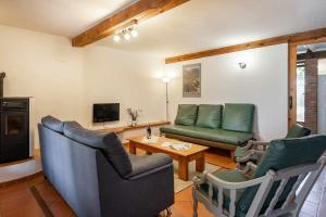uma sala de estar com um sofá, cadeiras e uma mesa em Casa con jardín cerca de la playa El porton em Miengo