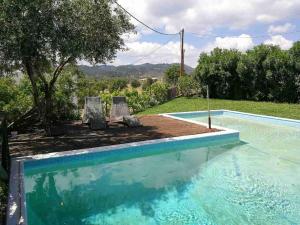 een zwembad met 2 stoelen en een boom bij Villa Frangipani with large private pool, Rhodes in Lardos