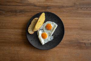 two eggs and a slice of bread on a plate at Moro Inn in Korčula