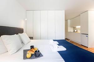ein Schlafzimmer mit einem Bett und einem Tablett mit Essen drauf in der Unterkunft Lapa Flat in City Center by LovelyStay in Porto