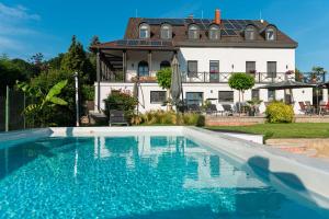 a swimming pool in front of a house at Katzer Villa in Badacsonytördemic