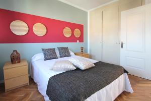 um quarto com uma cama grande e uma parede vermelha em Apartamentos Cinco Rosas em Madrid