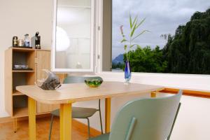 comedor con mesa, sillas y ventana en Villa Maria, en Lucerna