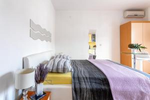 - une chambre avec un lit et une couverture violette dans l'établissement Apartments Dobrila, à Hvar