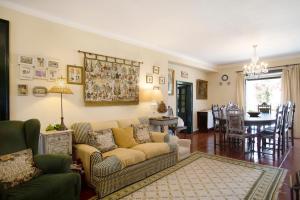 a living room with a couch and a dining room at Casa Alfeizerão in Alfeizerão