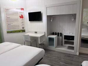 a hotel room with a bed and a desk and a tv at Ibis Styles Madrid Prado in Madrid